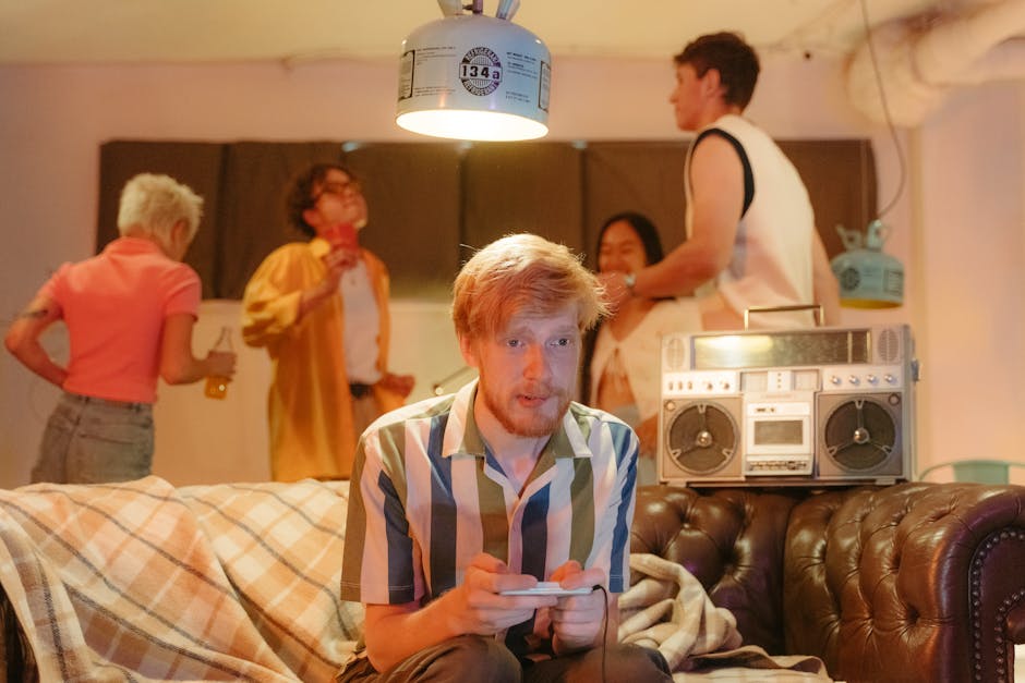 A group of young adults enjoying a retro-themed party with video games and a boombox.